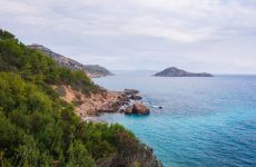Rocky coast line and water bay in winter, Tuscany, Italy. Monte Argentario natural park dramatic  sky pine forest mediterranean sea blue water.